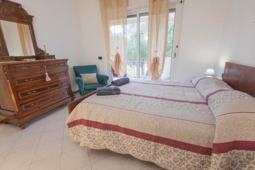 una camera con letto, cassettiera e specchio di Casa Olga a Vallecrosia