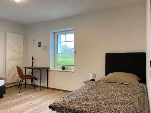 a bedroom with a bed and a table and a window at Haus Mariechen Whg 2 in der Nähe zum Silbersee mit gemütlicher Terrasse & Sauna in Frielendorf