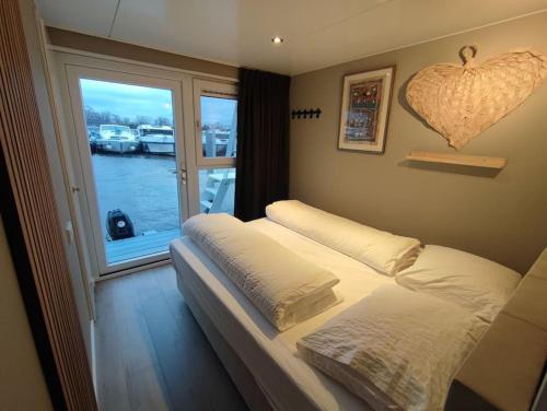 a bedroom with two beds and a window with boats at Atlanta. Een buitengewone ervaring. Dicht bij AMS. in Vinkeveen