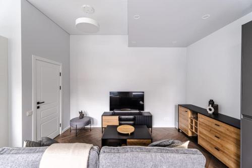 a living room with a couch and a table at Modern flat in Old Town Kaunas - Free Parking & Self Check-In in Kaunas