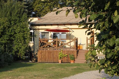 ein Haus mit einem Holztor und einem Sonnenschirm in der Unterkunft Ferienwohnung Seeidyll in Groß Köris