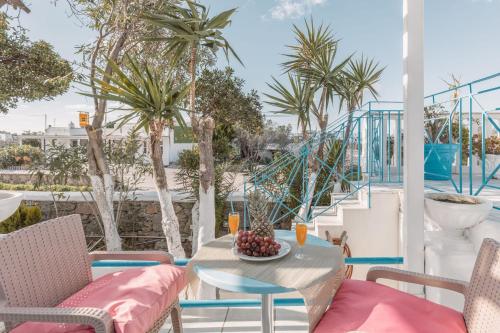 グラストロスにあるDibellee Mykonos boutique studiosのヤシの木が植わるバルコニー(テーブル、椅子付)