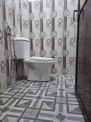 baño con aseo y pared estampada en PENGINAPAN 77, en Pulupanda