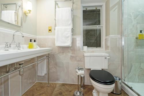 a bathroom with a toilet and a sink and a shower at Old Town House by Ezestays in Margate