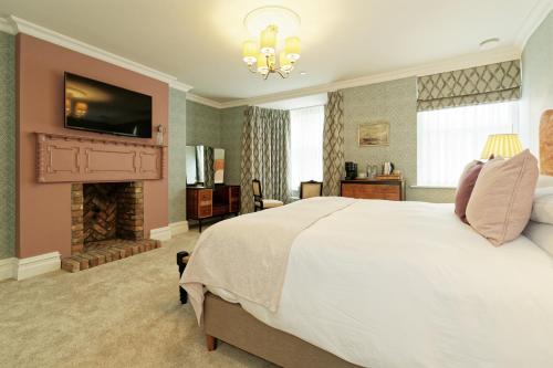 1 dormitorio con 1 cama grande y chimenea en Old Town House by Ezestays, IN THE HEART OF THE OLD TOWN MARGATE, en Margate