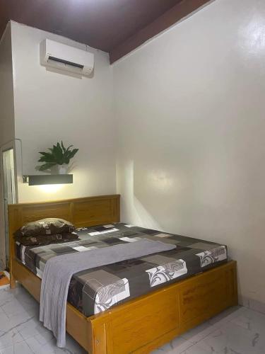 1 dormitorio con cama de madera en una habitación en PENGINAPAN 77, en Pulupanda