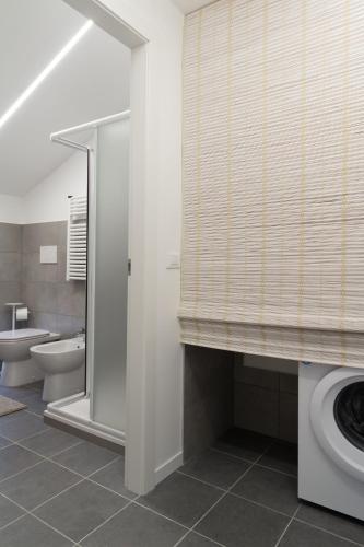 a bathroom with a toilet and a shower and a window at Matteotti Gallery Venice Apt in Mestre