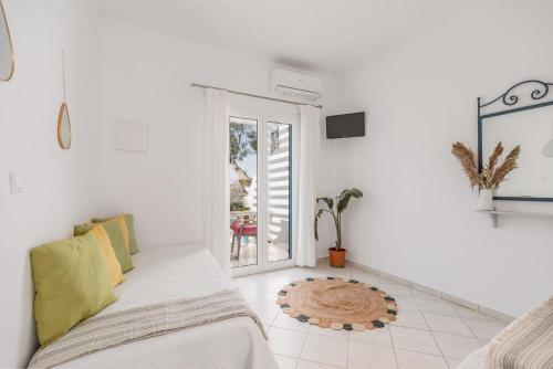 a white room with a bed and a window at Dibellee Mykonos Studios in Glastros