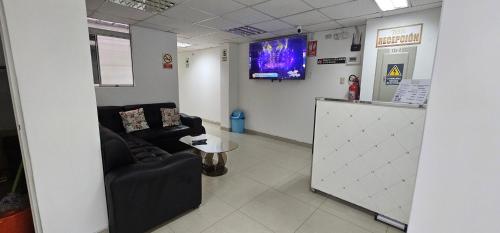 una sala de espera con sofá y TV en HOTEL TICLIO, en Cajamarca