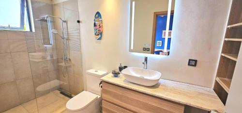 a bathroom with a sink and a toilet and a shower at Golf View Villa in Roches Noires