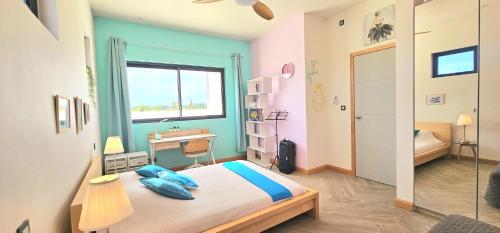 1 dormitorio con cama, escritorio y ventana en Golf View Villa, en Roches Noires