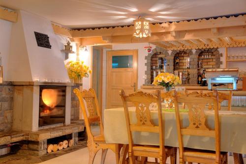 a dining room with a table and a fireplace at Willa Pod Orłem Jacuzzi Sauna in Kościelisko