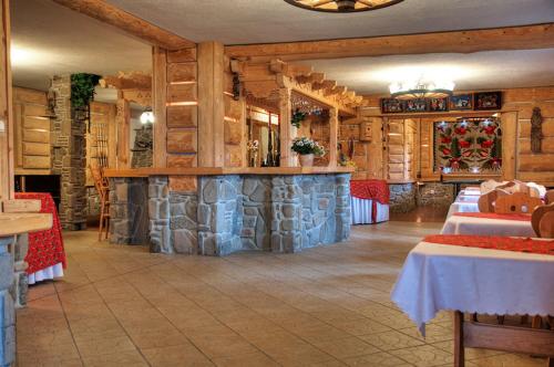 a restaurant with a bar in the middle of a room at Willa Pod Orłem Jacuzzi Sauna in Kościelisko