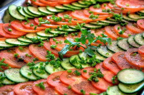 a tray of vegetables with tomatoes cucumbers and parsley at Willa Pod Orłem Jacuzzi Sauna in Kościelisko