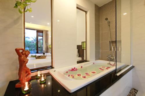 a bath tub in a bathroom with a mirror at Green Boutique Villa in Hoi An