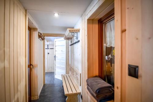 a hallway with a bench and a door with a window at Willa Pod Orłem Jacuzzi Sauna in Kościelisko