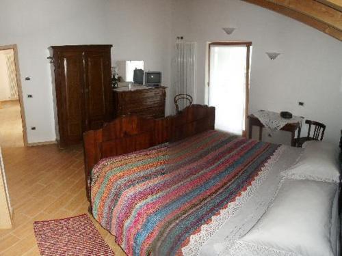 a bedroom with a large bed with a striped blanket at Agriturismo Le Cavade in Cembra