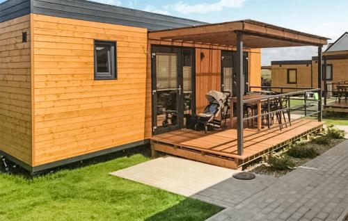 a tiny house with a deck with a table at Cozy Home In Rewal With Kitchen in Rewal