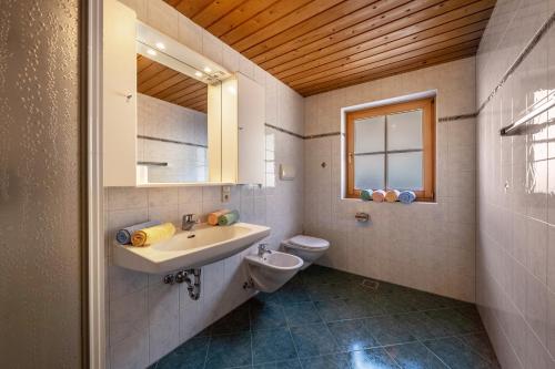 uma casa de banho com um lavatório, um WC e um espelho. em Thalhof Laugen em Ultimo