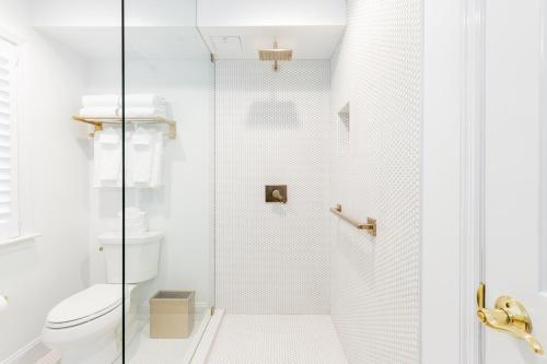 a bathroom with a toilet and a glass shower door at The Beach Club on Madison Avenue in Cape May