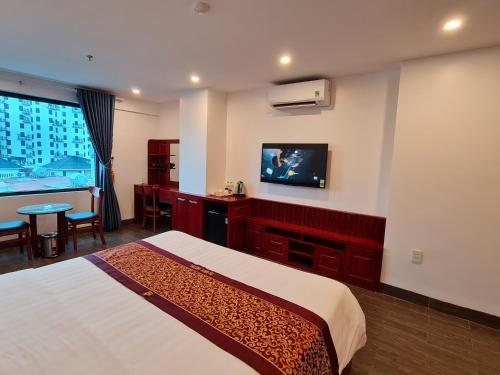 a hotel room with a bed and a flat screen tv at glory 3 hotel 北宁格洛瑞3好酒店 in Bồ Sơn