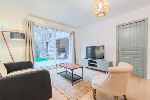 un salon avec un canapé, une table et une télévision dans l'établissement One bedroom apartment with parking & terrace, à Croix