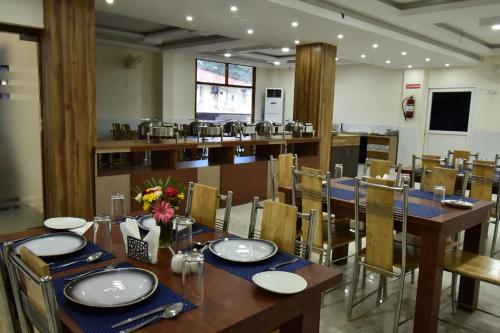 uma grande sala de jantar com mesa e cadeiras em SRI KPN HOTEL em Port Blair