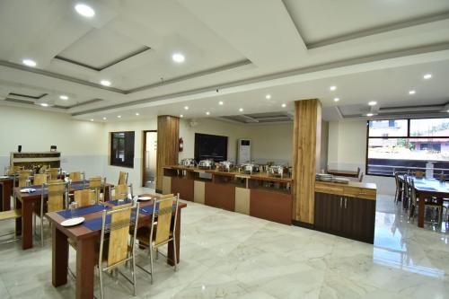 a restaurant with tables and chairs and a bar at SRI KPN HOTEL in Port Blair