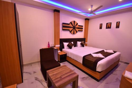 a hotel room with a bed and a chair at SRI KPN HOTEL in Port Blair