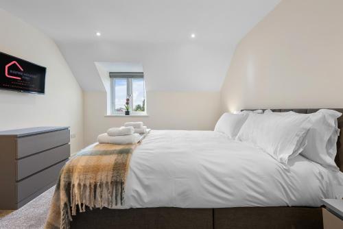 um quarto com uma cama com lençóis brancos e uma janela em New Apartment in Stockton, sleeps 4, Free WIFI 
