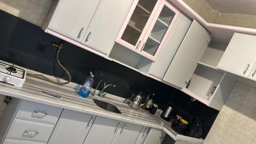 a kitchen with white cabinets and a sink at Black in Köseilyas