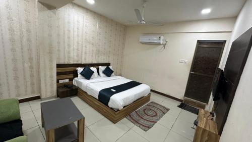 Un dormitorio con una cama y un televisor. en Hotel New Shiv Kunj, en Vadodara