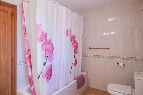 a bathroom with a shower curtain with pink flowers on it at Can Bielo by Rentallorca in Lloret de Vistalegre