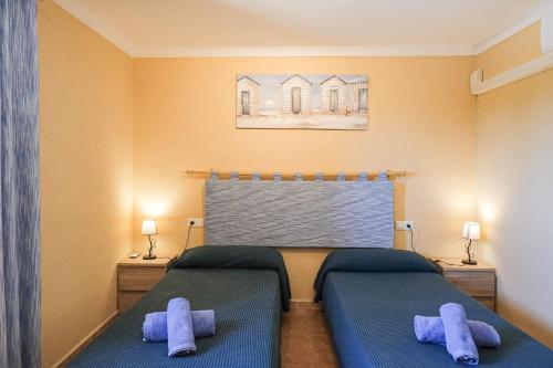 a bedroom with two beds with blue pillows at Can Bielo by Rentallorca in Lloret de Vistalegre