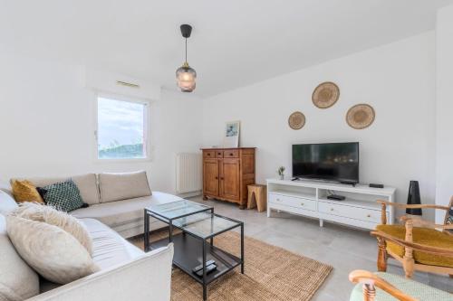 un salon avec un canapé et une télévision dans l'établissement Beautiful 4 bedroom house with parking and garden, à Wasquehal