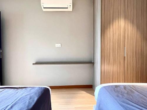 a bedroom with two beds and a cabinet with a heater at HillLand Suites in Ayer Keroh