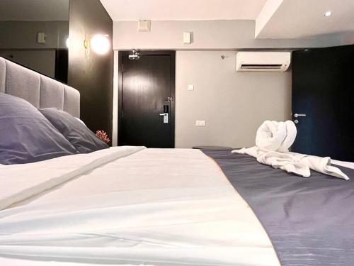 a bedroom with a large bed with white sheets at HillLand Suites in Ayer Keroh