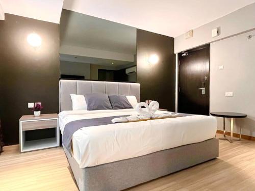 a bedroom with a large bed with a towel on it at HillLand Suites in Ayer Keroh