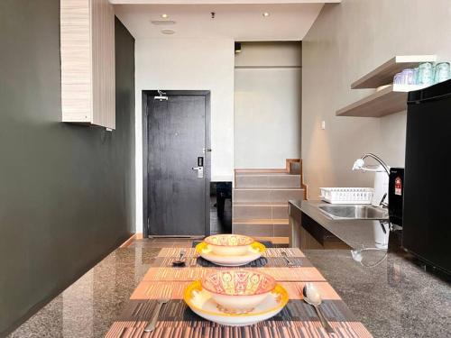 a kitchen with two plates on a table at HillLand Suites in Ayer Keroh