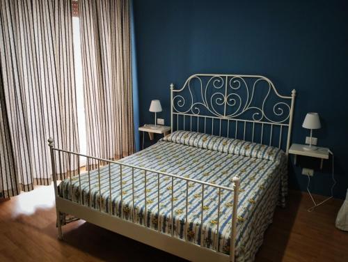 a bed in a blue room with two nightstands and two lamps at Vista sul Tevere in Rome