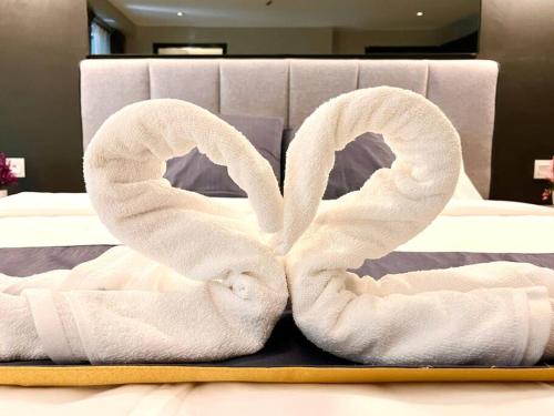 two towels shaped like hearts are on a bed at HillLand Suites in Ayer Keroh