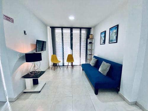 sala de estar con sofá azul y algunas ventanas en La palma- casa amoblada Palma Mayorca, en Sincelejo