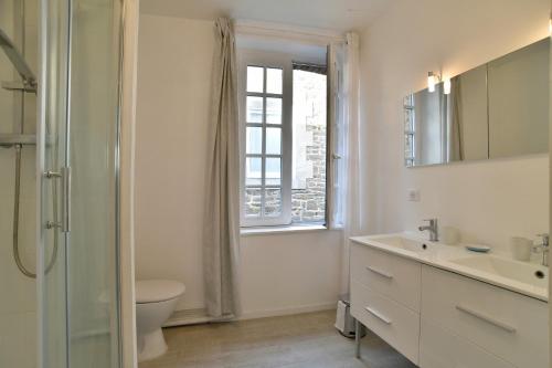a bathroom with a sink and a toilet and a window at L'Escale Cancalaise - Maison de pêcheur 150m du port in Cancale