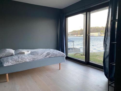 a bedroom with a bed with a view of the water at Unikt feriested med stor privat brygge in Bamble