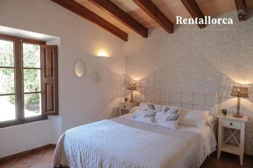 een slaapkamer met een wit bed en een raam bij Finca Ca'n Sec by Rentallorca in Sóller