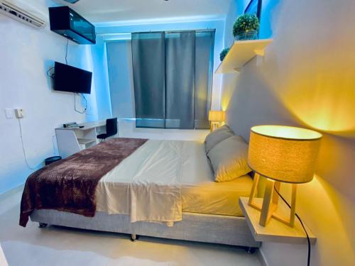 1 dormitorio con 1 cama, 1 mesa y 1 lámpara en La palma- casa amoblada Palma Mayorca, en Sincelejo
