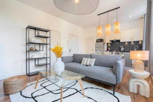 salon z kanapą i stołem w obiekcie Modern, quiet 3-bedroom apartment with parking w mieście Marcq-en-Barœul