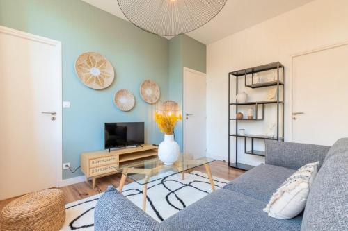 un salon avec un canapé et une télévision dans l'établissement Modern, quiet 3-bedroom apartment with parking, à Marcq-en-Barœul