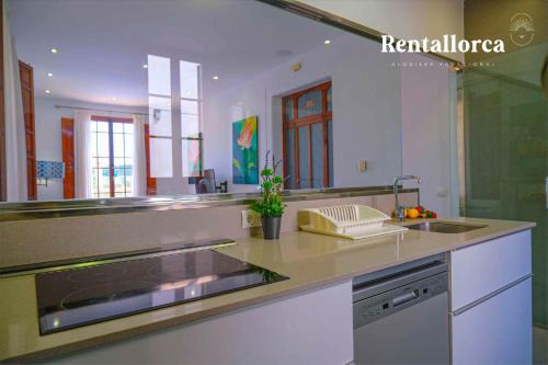 Can Bombarda by Rentallorca في يوبي: مطبخ مع حوض و كونتر توب