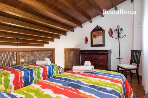 a bedroom with two beds with colorful blankets at Finca Ses Contesas by Rentallorca in Alcudia